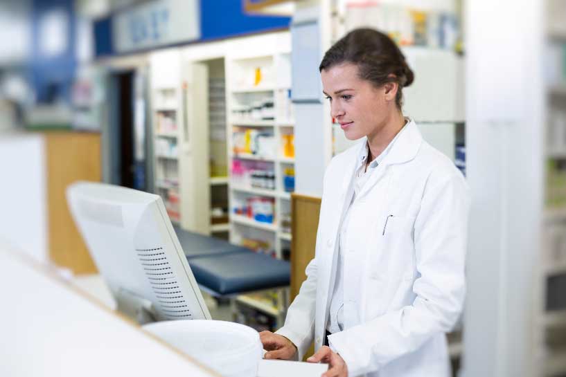 A pharmacist looks at her computer