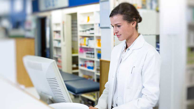 A pharmacist looks at her computer